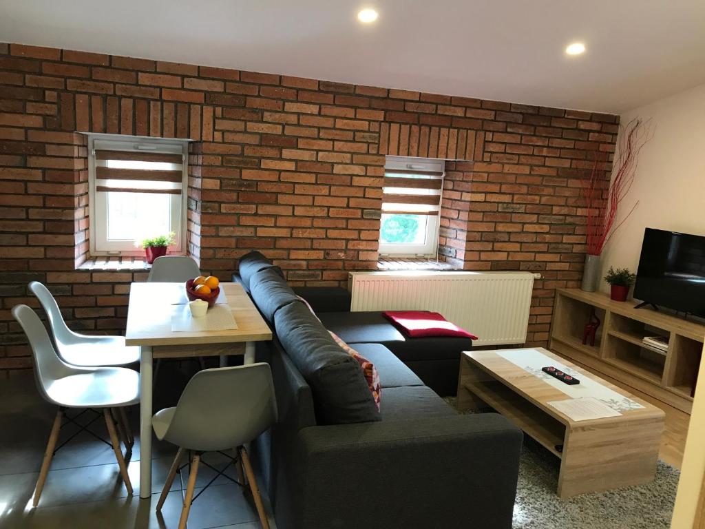 a living room with a couch and a brick wall at Intermo II in Świętochłowice