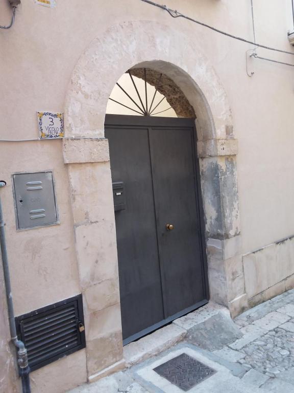 una puerta negra en el lateral de un edificio en Casa vacanza Giglio, en Noto
