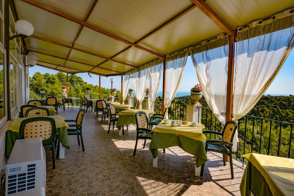 a restaurant with tables and chairs on a balcony at Albergo Godenizzo in Peschici