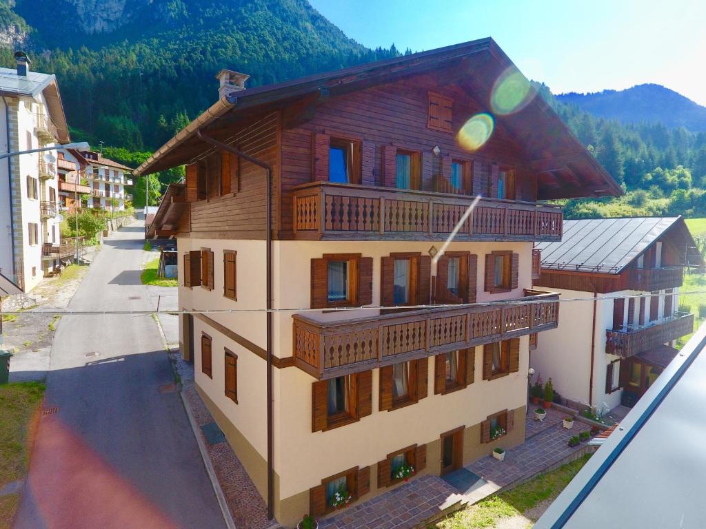 a large building with wooden balconies on a street at Ajarnola Locazioni Turist in Auronzo di Cadore