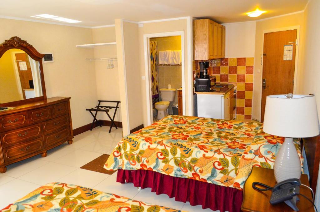 a bedroom with a bed and a dresser and a bathroom at Fantastic Hotel in Marigot