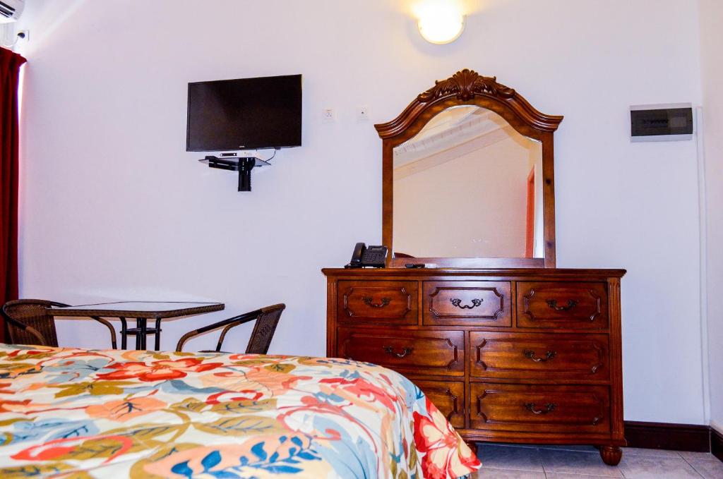 a bedroom with a dresser with a mirror and a bed at Fantastic Hotel in Marigot