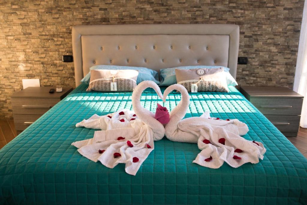 two swan towels are laying on a bed at Acqua Azzurra in Alghero