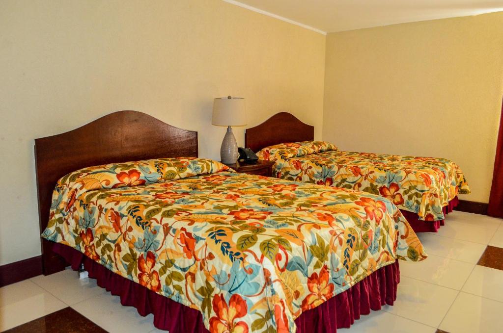 a hotel room with two beds and a lamp at Fantastic Hotel in Marigot