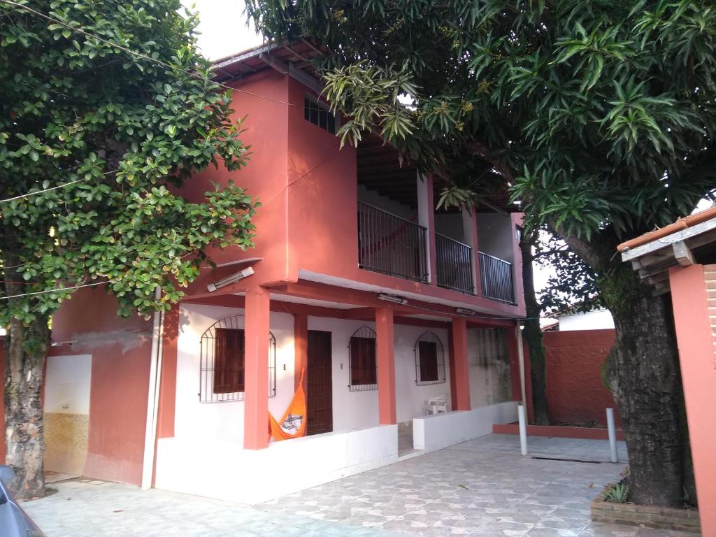 a red and white building with trees in front of it at Casa do Mineiro in Nova Viçosa