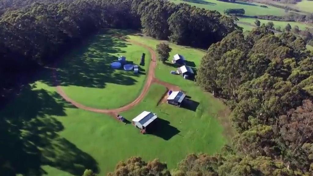 an aerial view of a farm in the middle of a field at Tinglewood Cabins in Walpole