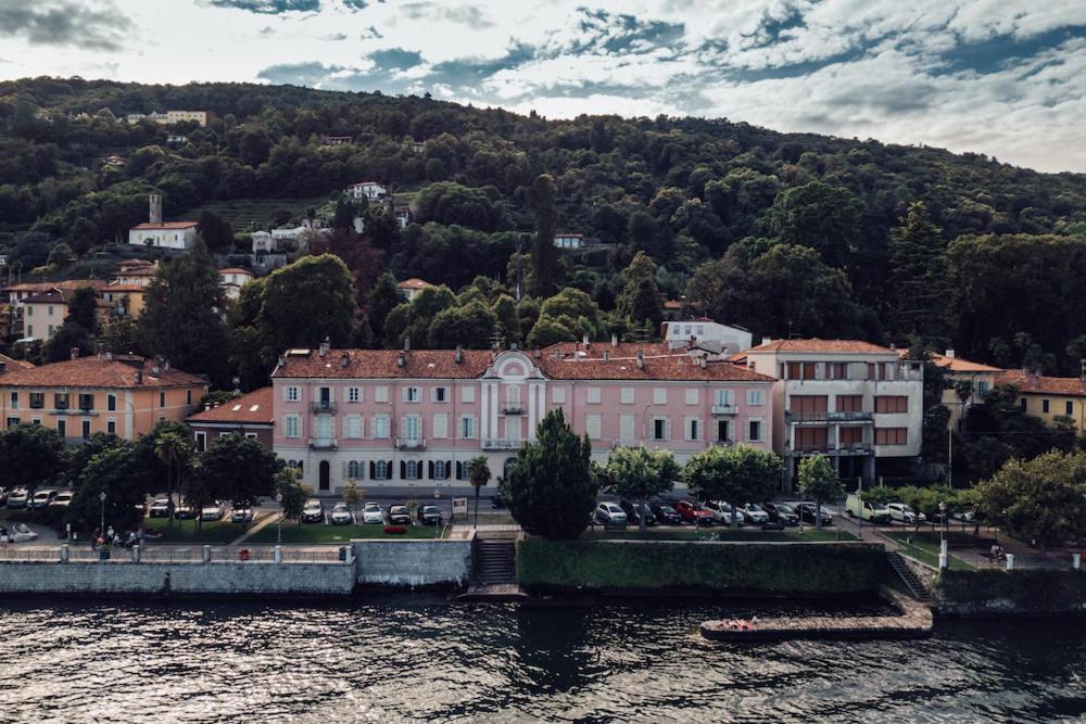 un groupe de bâtiments à côté d'une masse d'eau dans l'établissement Villa Martelli, à Belgirate