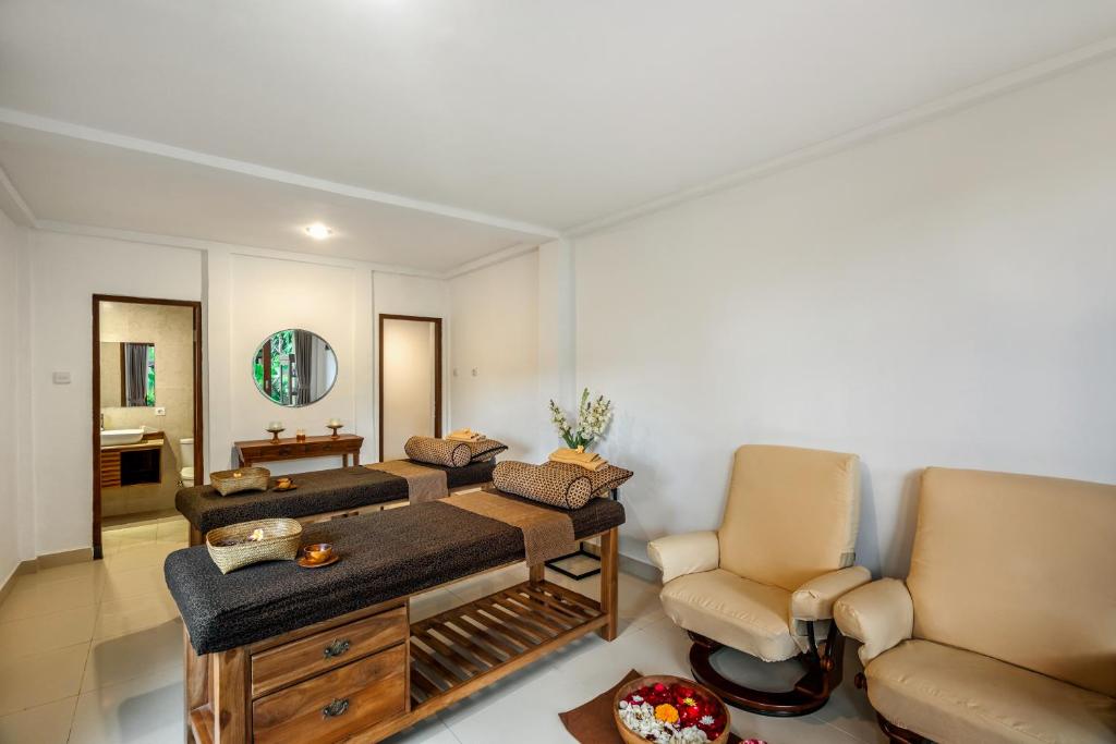 a living room with a couch and two chairs at Jati Cottage in Ubud
