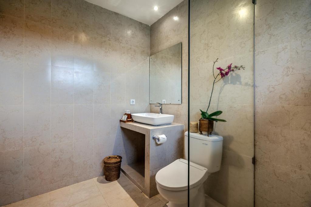 a bathroom with a toilet and a sink at Jati Cottage in Ubud