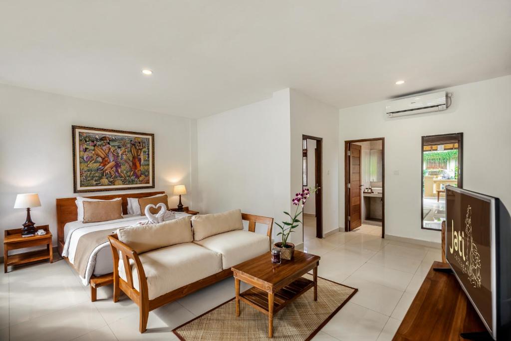 a living room with a bed and a couch at Jati Cottage in Ubud