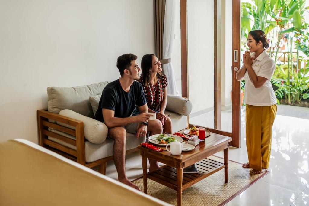 a group of people sitting in a living room at Jati Cottage in Ubud