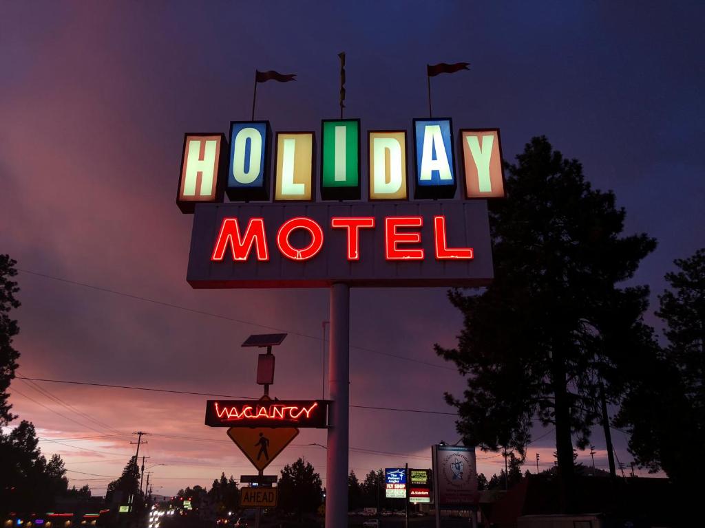 a sign for a motel with a neon sign at Holiday Motel Bend in Bend