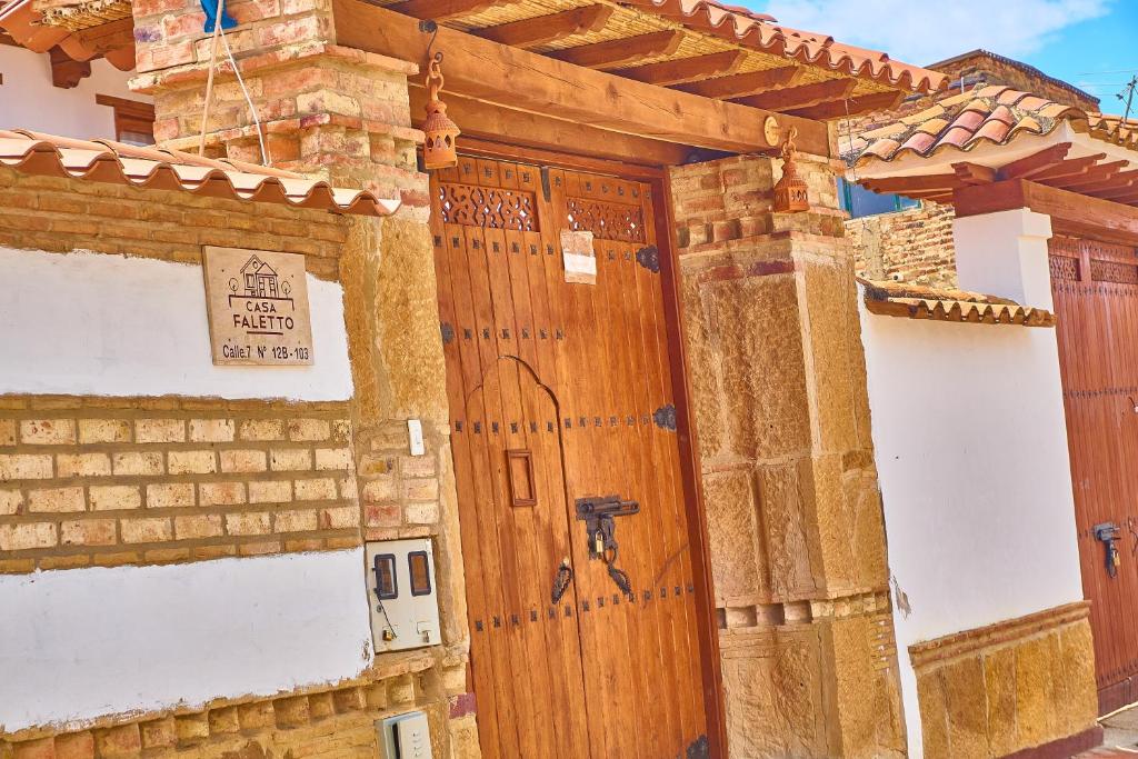 een houten deur aan de zijkant van een gebouw bij Casa de Huéspedes Faletto in Villa de Leyva