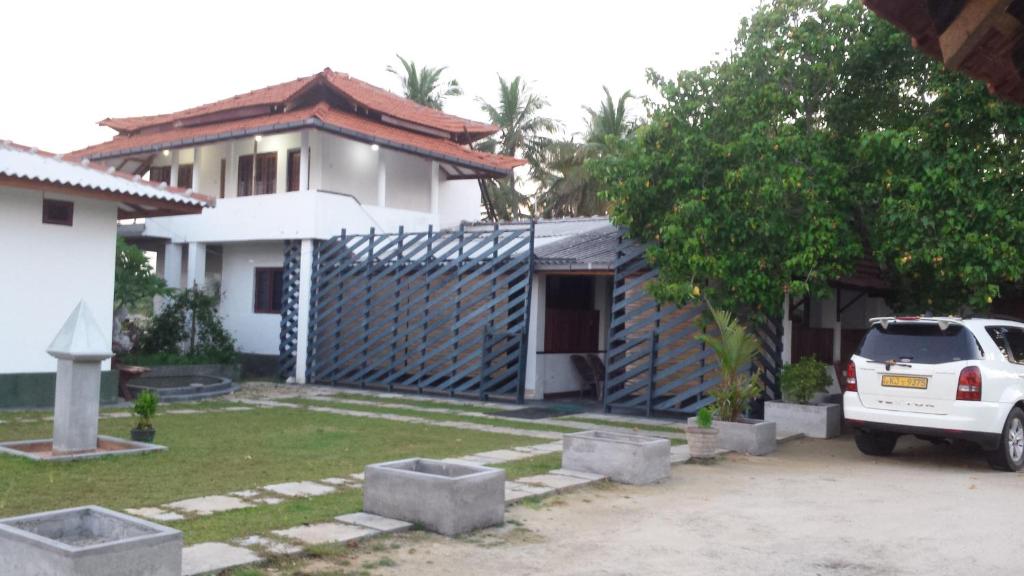 a white car parked in front of a house at Anoleth in Kalpitiya