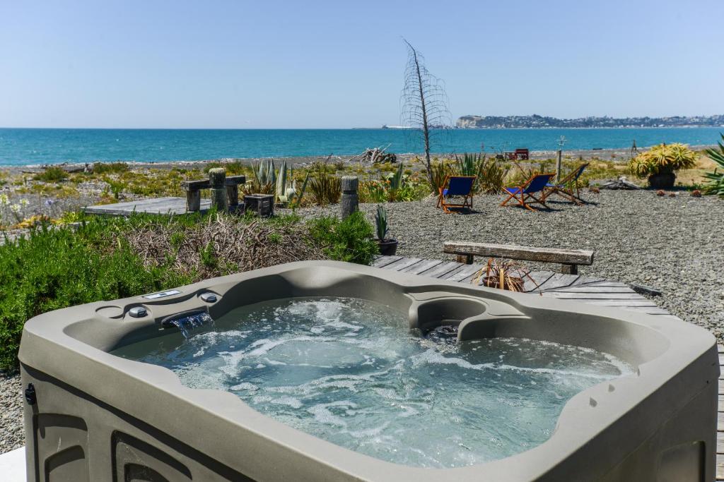 a bath tub sitting on top of a beach at Absolute Beachfront B&B in Napier