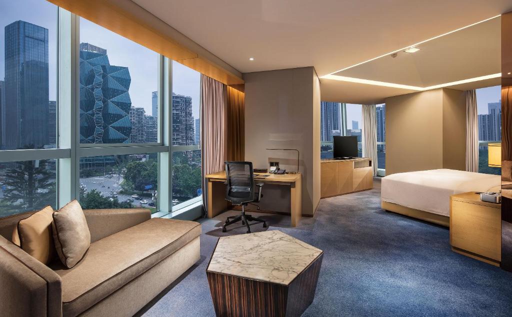 a hotel room with a bed and a couch and a desk at Seaton International Hotel Chengdu in Chengdu