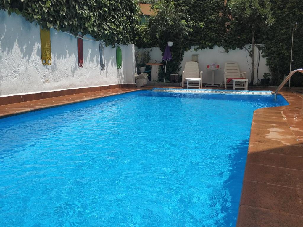 una gran piscina de agua azul en Apartamentos Lara en Granada