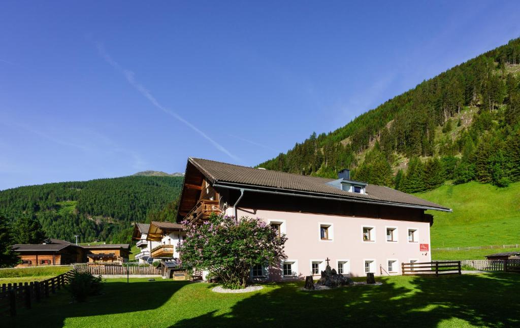 a large white building with a hill in the background at Ferienhaus Meins in Kals am Großglockner