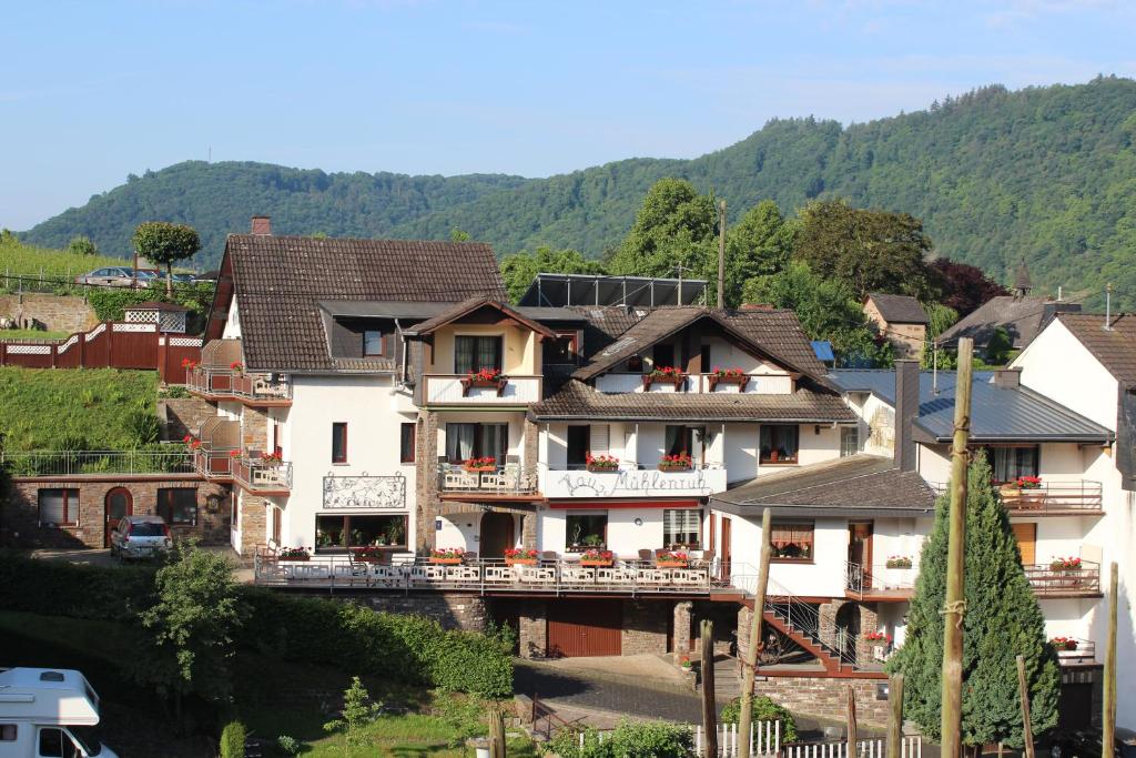 ein Haus in einem Dorf mit Bergen im Hintergrund in der Unterkunft Haus Mühlenruh in Bruttig-Fankel