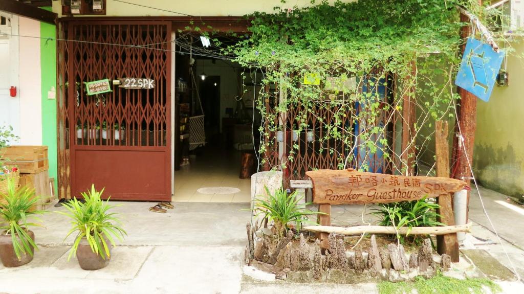 a bench sitting in front of a building with plants at Pangkor Guesthouse SPK in Pangkor