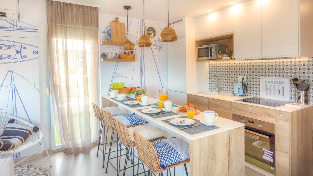 een keuken met een aanrecht met stoelen en een tafel bij Nikky’s BLUE DREAM Apartment in Mali Lošinj