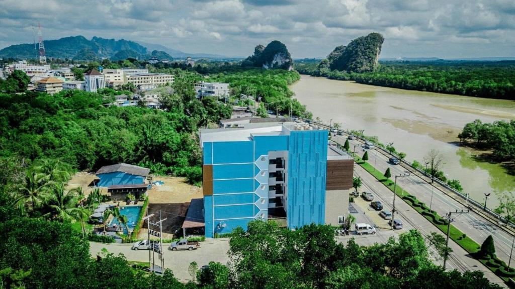 a building next to a river next to a city at River Front Krabi Hotel in Krabi