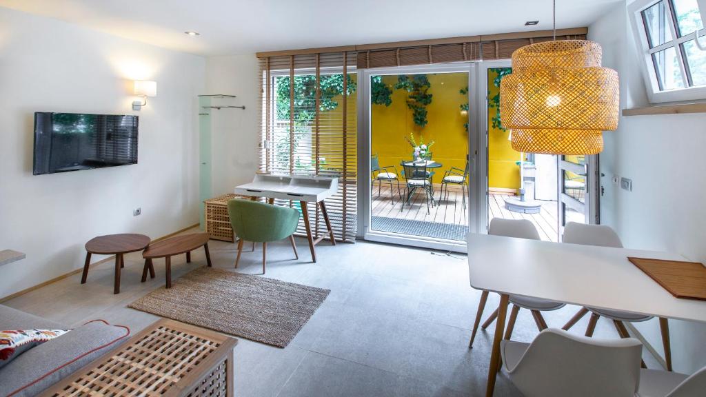 ein Wohnzimmer mit einem Tisch und Stühlen sowie ein Esszimmer in der Unterkunft City Apartments Green Oasis in Ljubljana