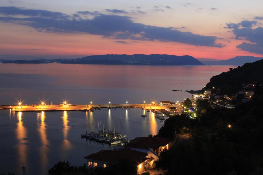 a view of a harbor at night at Aegean Wave - Faros in Loutraki