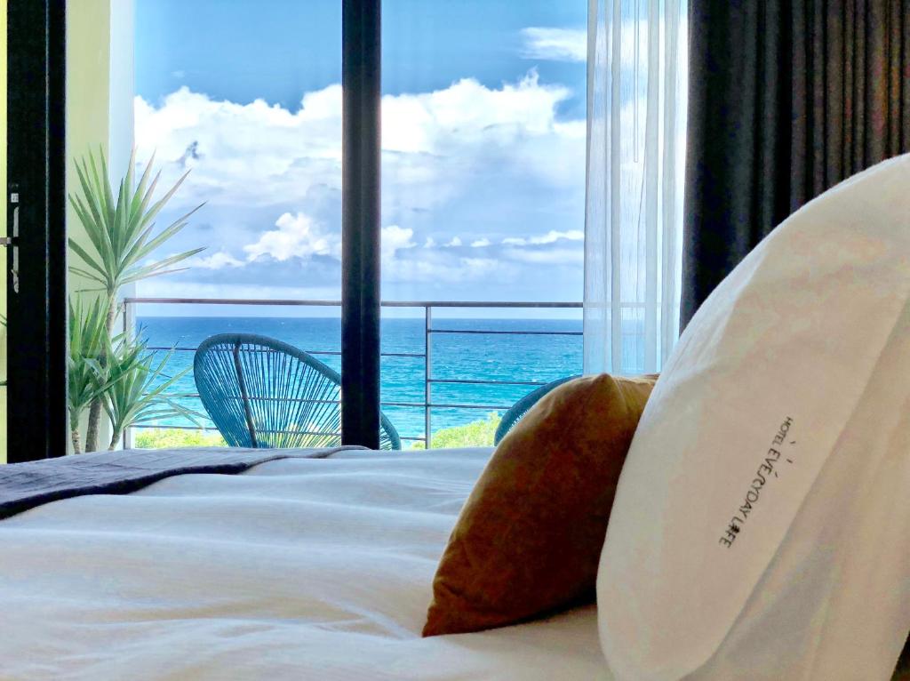 a bedroom with a bed with a view of the ocean at Hotel Everyday Life in Eluan