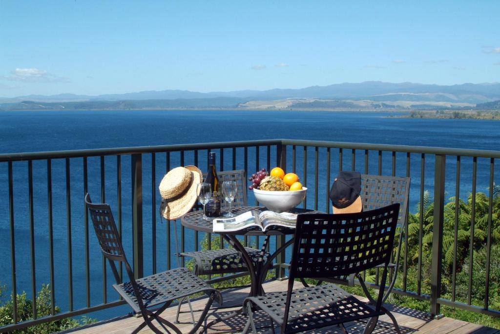 una mesa y sillas con un bol de fruta en el balcón en Oreti Village Resort en Turangi