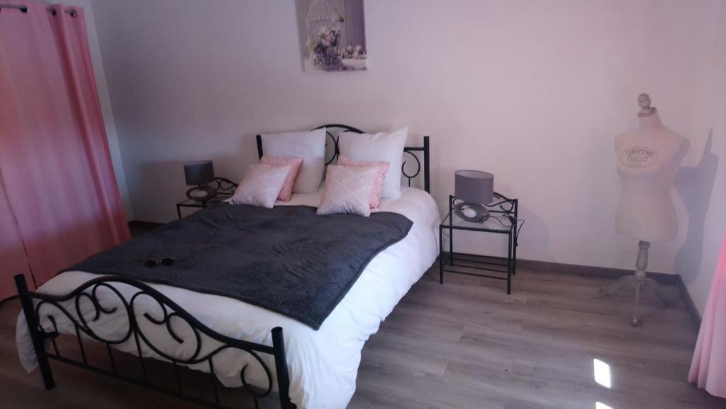 a bedroom with a large bed with pink pillows at Le Gite de l'Etrier in Canchy