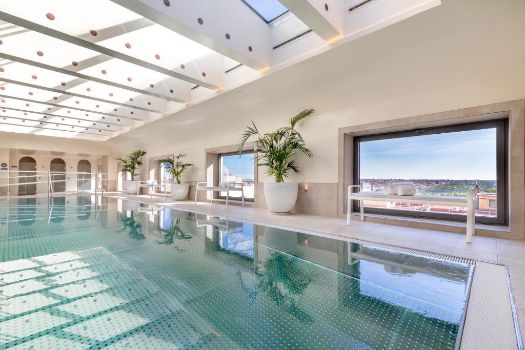 a swimming pool with plants in a building at Barceló Torre de Madrid in Madrid