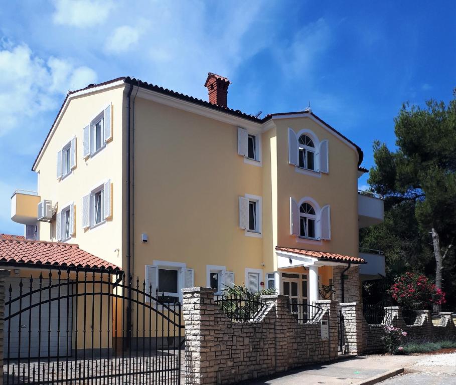 ein großes weißes Haus mit einem Steinzaun in der Unterkunft Ribarska Koliba - Villa Marija in Pula