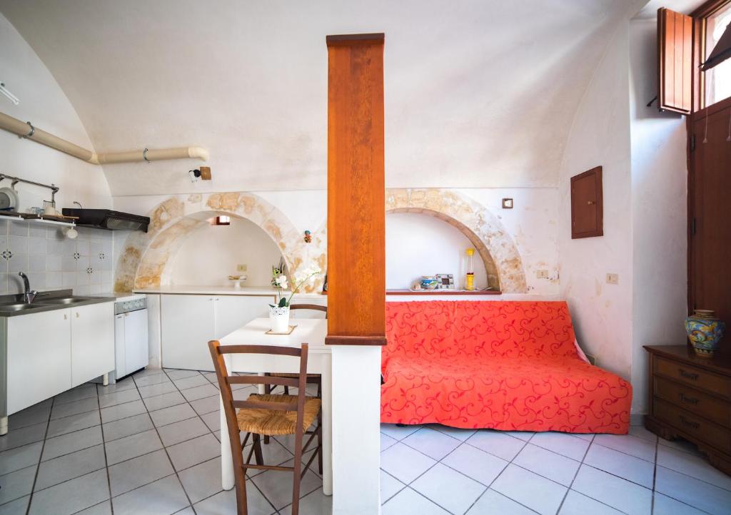 eine Küche mit einem Tisch und einem roten Bett in einem Zimmer in der Unterkunft Latte&Miele in Ragusa