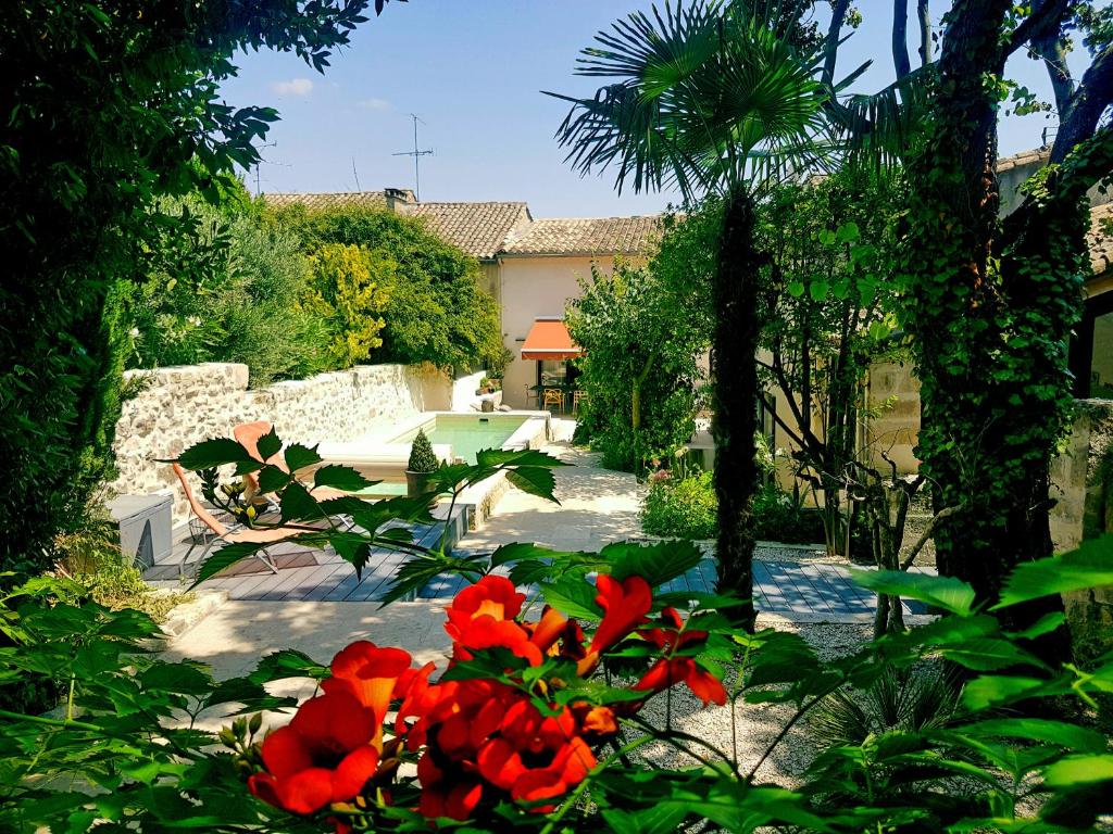 a garden with red flowers in front of a house at les bignones in Uzès