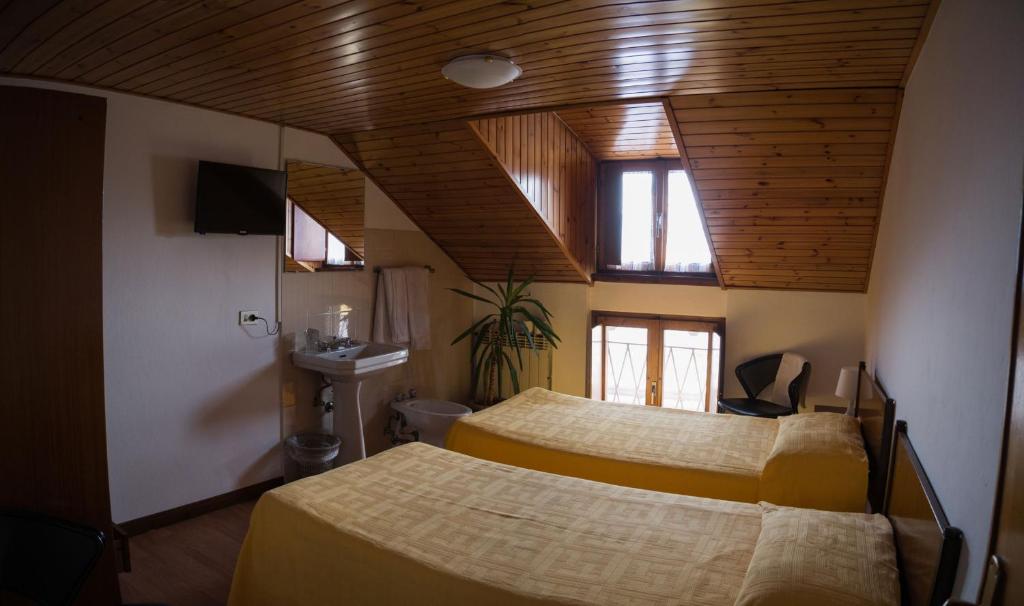 カスティオーネ・デッラ・プレゾラーナにあるB&B Edelweissのベッドルーム1室(ベッド2台付)、天井(窓付)が備わります。