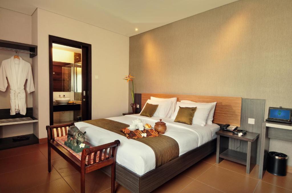 a hotel room with a large bed and a table at Sukajadi Hotel, Convention and Gallery in Bandung