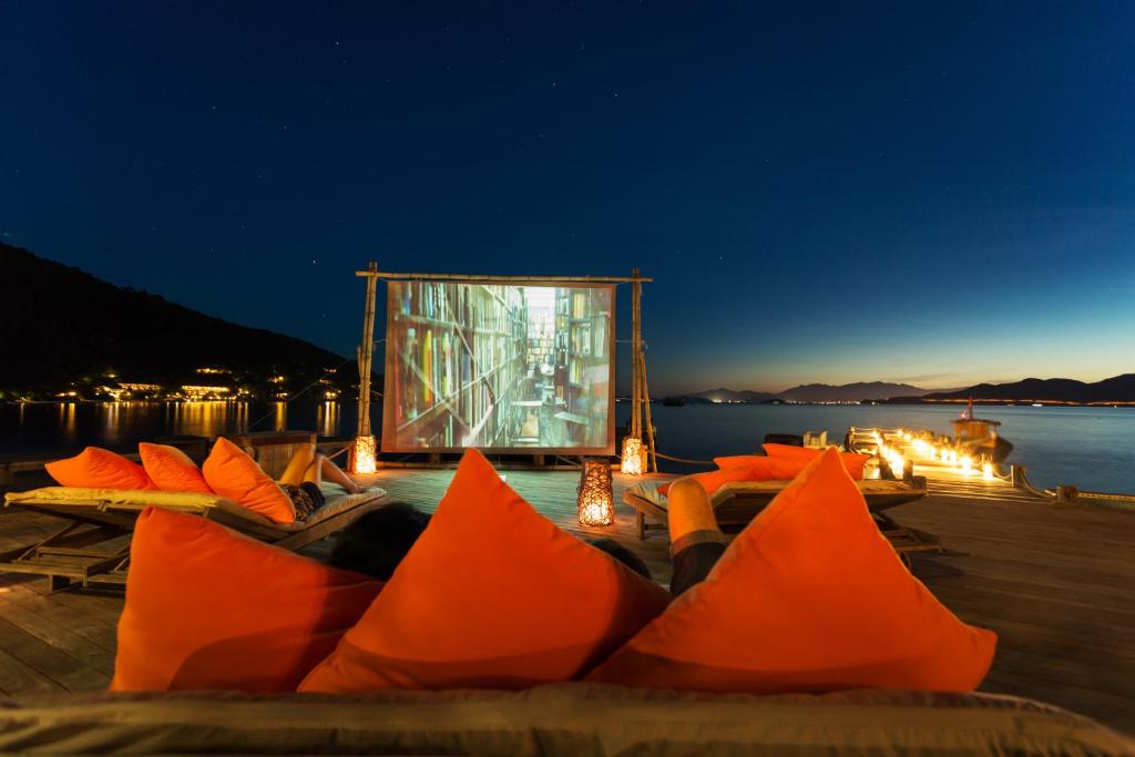 a group of orange pillows on a dock at night at Six Senses Ninh Van Bay in Ninh Van Bay
