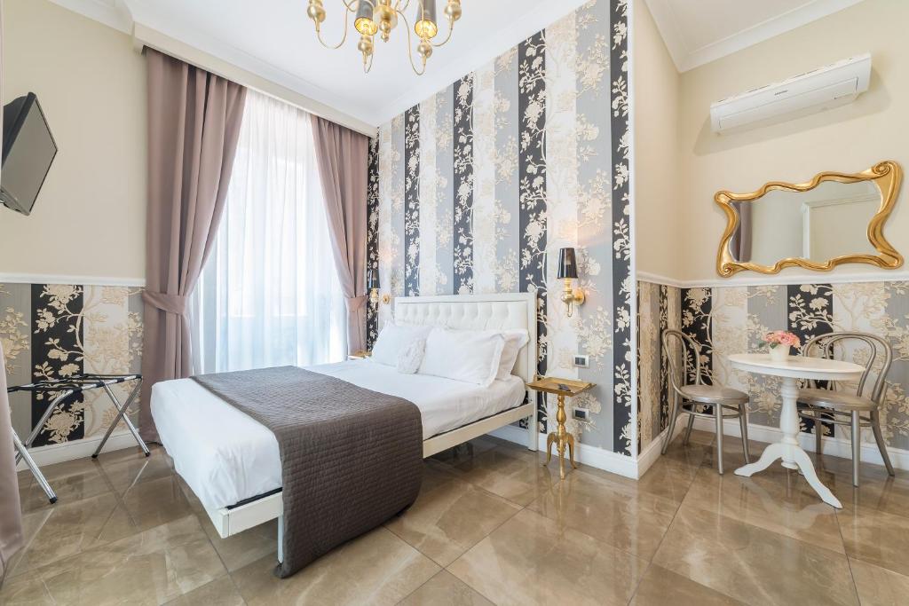 - une chambre avec un lit, une table et un miroir dans l'établissement Le Chiavi di Roma, à Rome