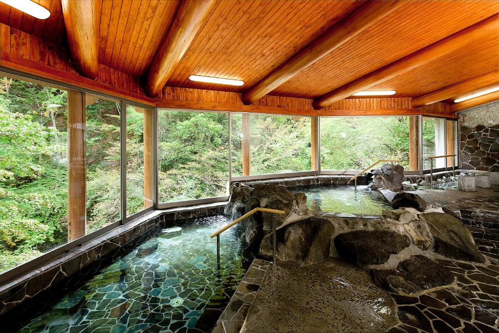 una grande piscina d'acqua in una stanza con finestre di Hana to Hana a Nikko