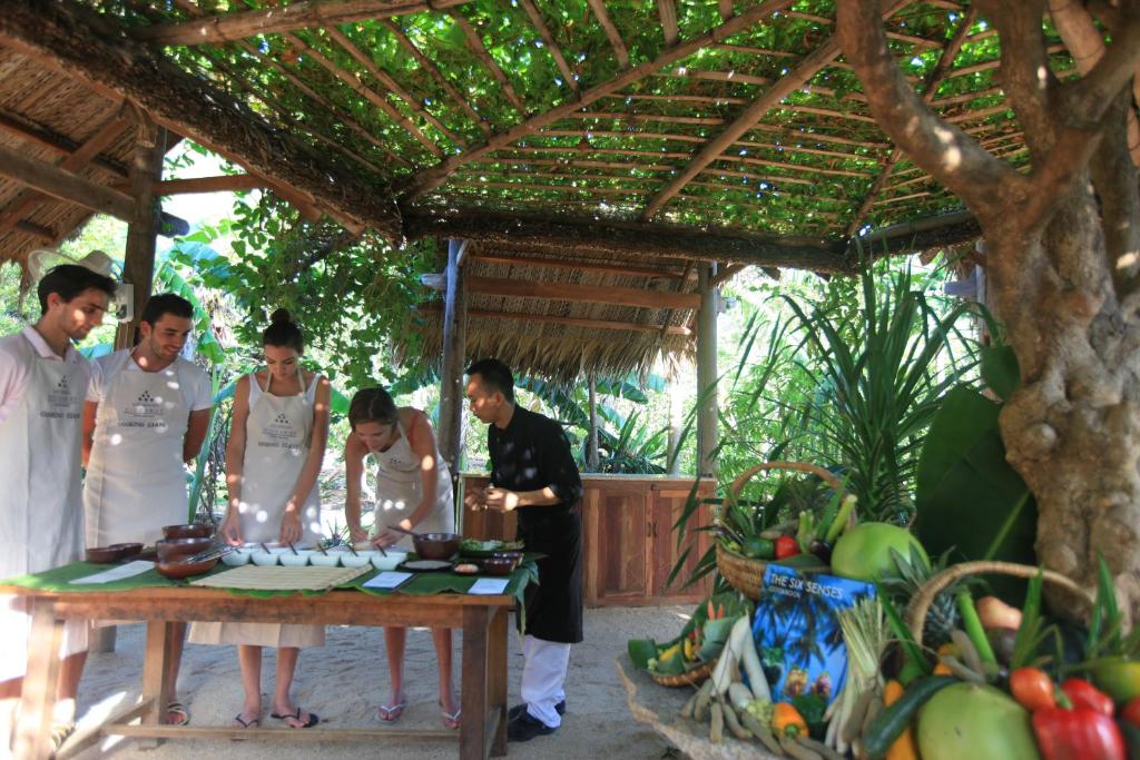 a group of people standing around a table at Six Senses Ninh Van Bay in Ninh Van Bay