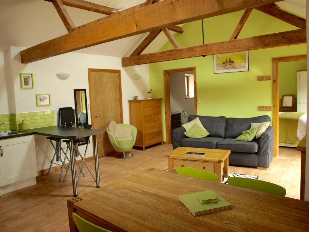 un soggiorno con divano e tavolo di The Courtyard at Lodge Farm a Norwich