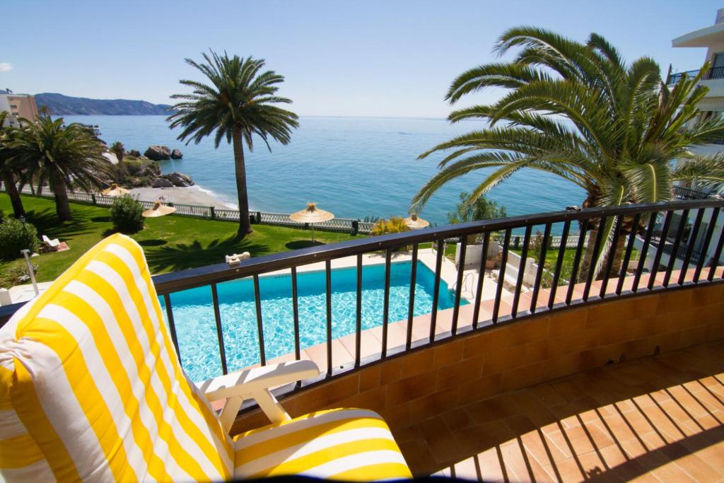 einen Balkon mit Pool, Palmen und Meerblick in der Unterkunft Acapulco Playa 34 Menyber in Nerja