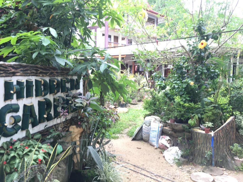 einen Garten mit einem Schild, das den älteren Garten liest in der Unterkunft Hidden Garden Pensione in El Nido