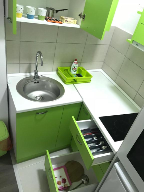 a small kitchen with green cabinets and a sink at La Apartamento in Jagodina