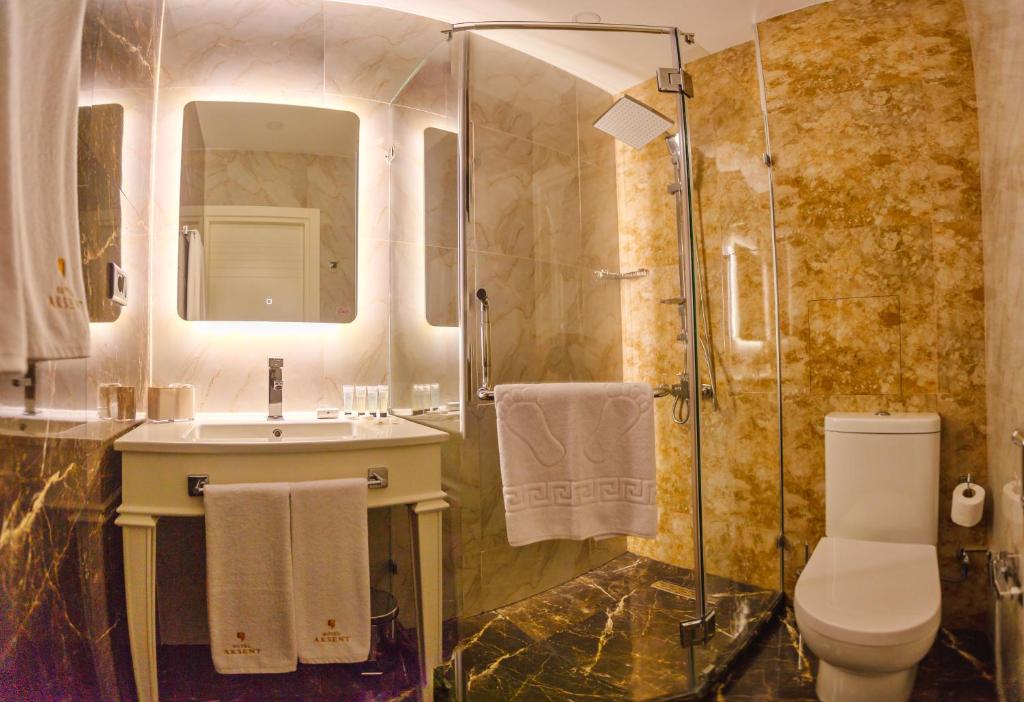 a bathroom with a toilet and a sink and a shower at Aksent Hotel in Baku