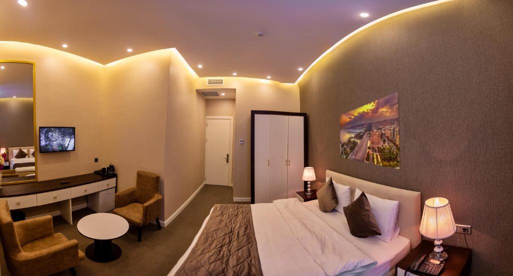 a bedroom with a bed and a desk in a room at Aksent Hotel in Baku