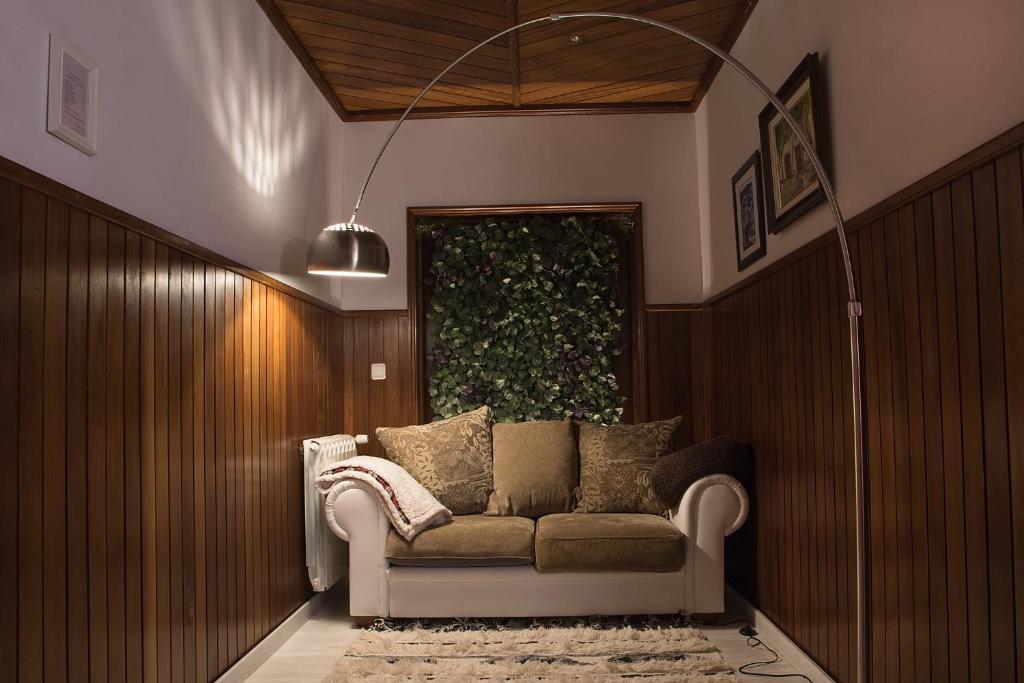 un sofá en una habitación con una pared verde en The Rooftop Suites, en Peso da Régua