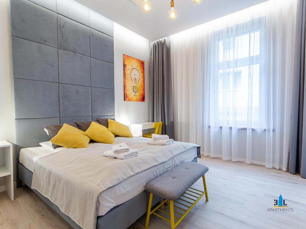 コウォブジェクにある3L Apartments Exclusiveのベッドルーム1室(大型ベッド1台、黄色い枕、椅子付)