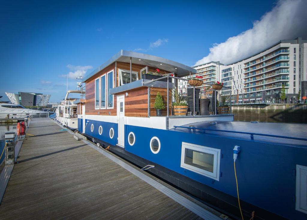 a house boat parked next to a dock at Barge At Titanic in Belfast